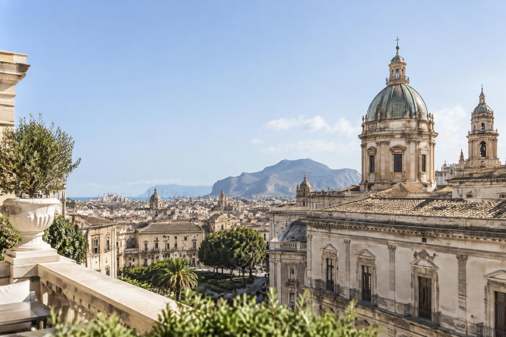 Vista luminosa su una città mediterranea con palazzi storici e cupole